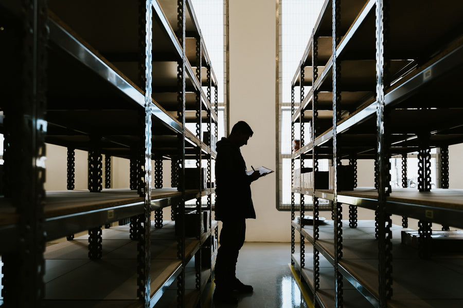 Person checking inventory with a clipboard in a warehouse