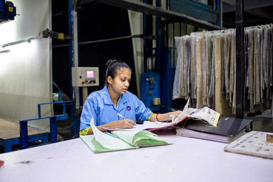Worker reviewing documents at a factory workstation